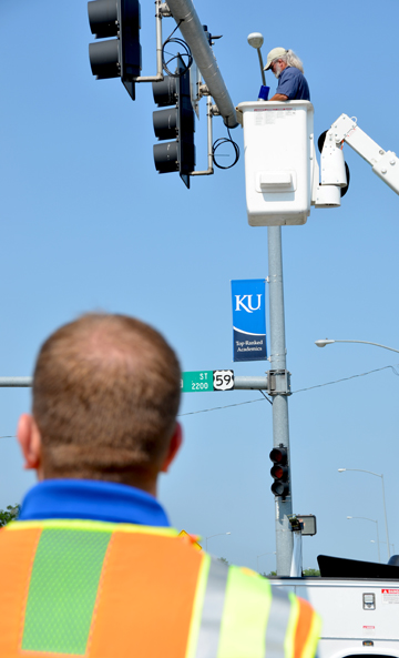 The City of Lawrence worker installing the blue light confirmation system