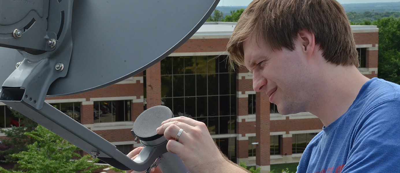 Student adjusting a satellite dish