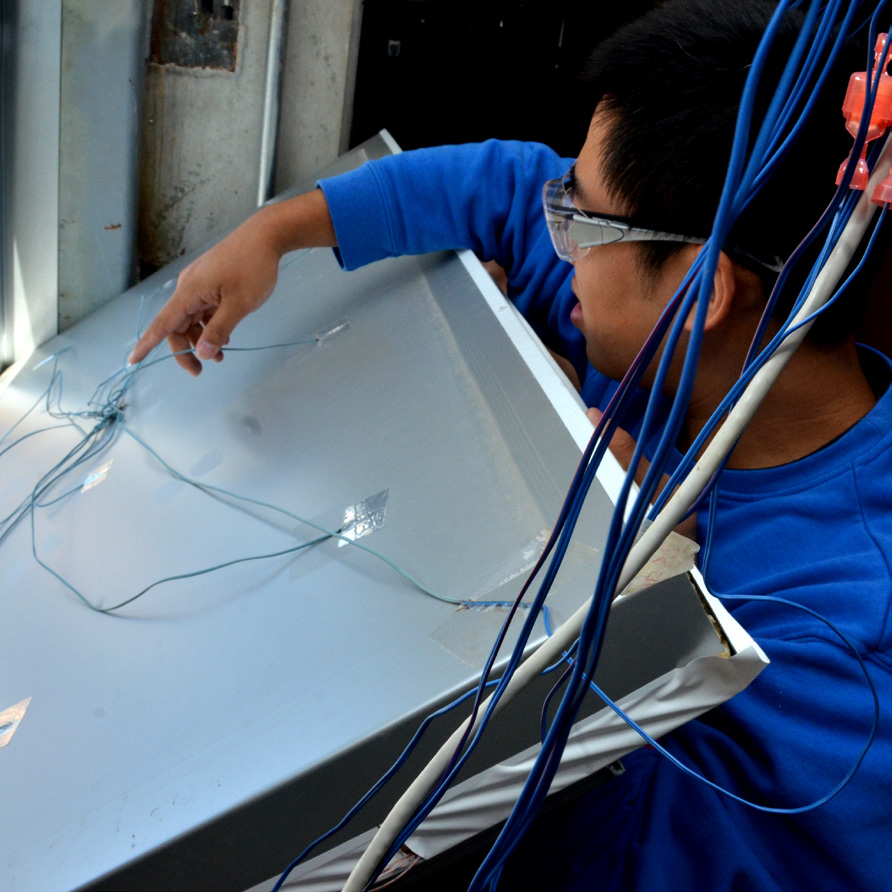 A student pointing at wires on a panel