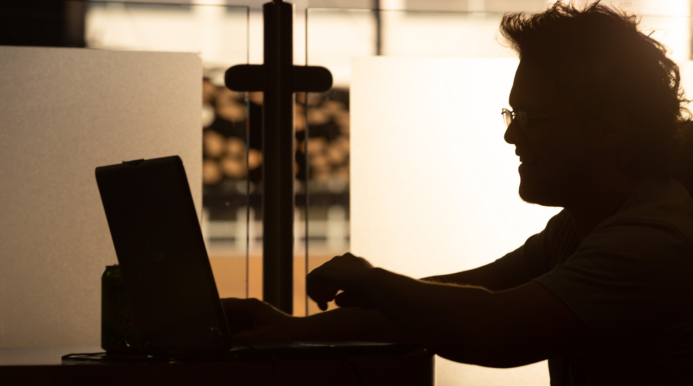 silhouette of a person at a computer