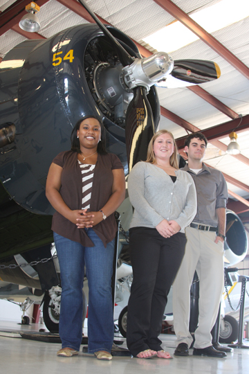 Lauren Fitzpatrick, Sarah Kulhanek, and Chris Vaughn in front of a propeller plane