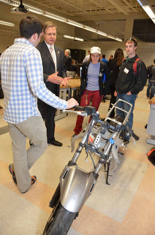 Provost Jeff Vitter learns about a senior project to convert an IC motorcycle to electric.