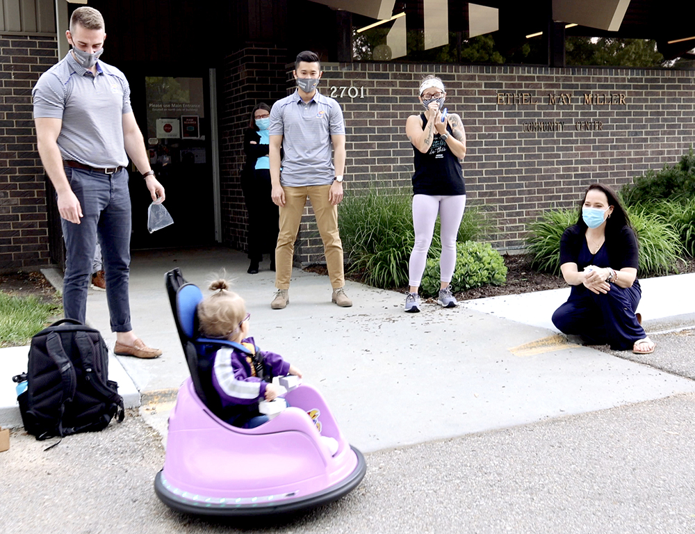 Amira in her scooter as her mother and KU engineering students watch her use it