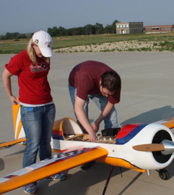 People working on a drone on an airfield
