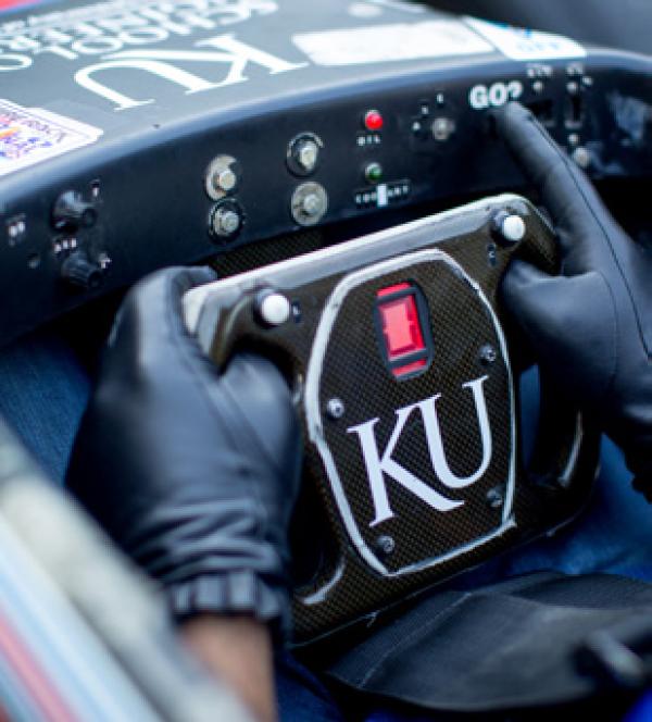 A steering wheel for a racecar that says KU on it