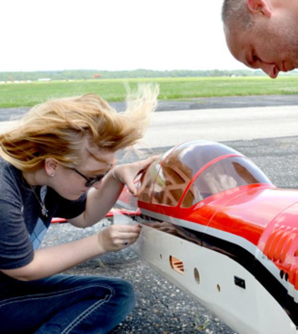 people working on a drone on an airstrip
